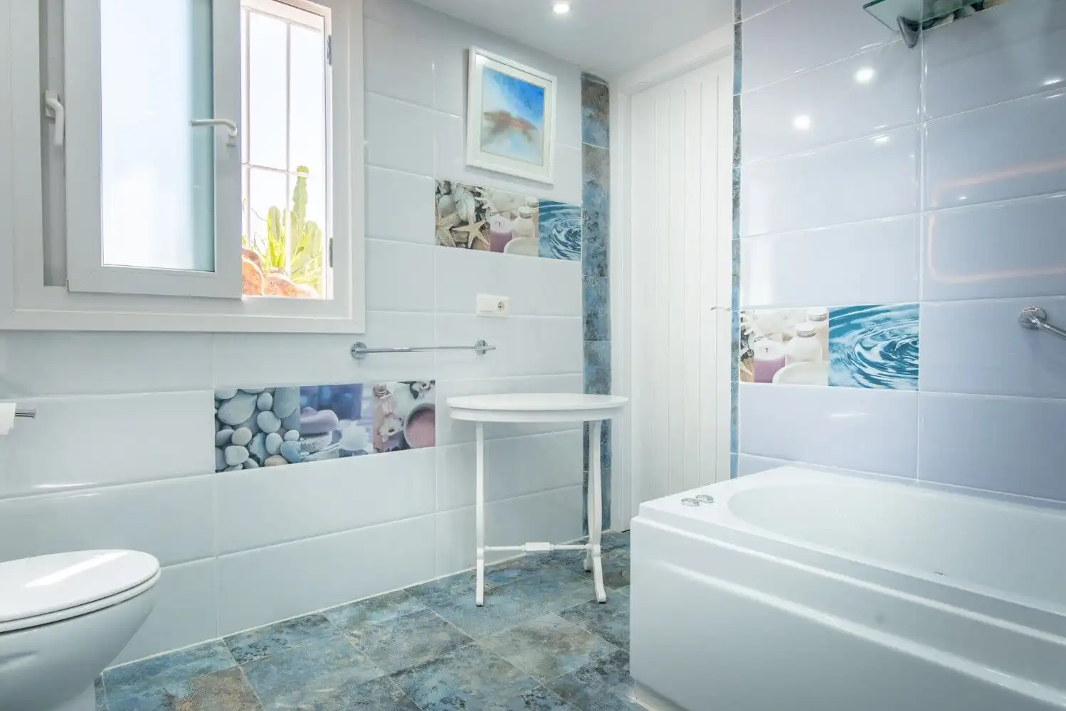 Bright bathroom with bathtub, toilet, and window in Los Llanos, Estepona. Stylish, clean, and functi.