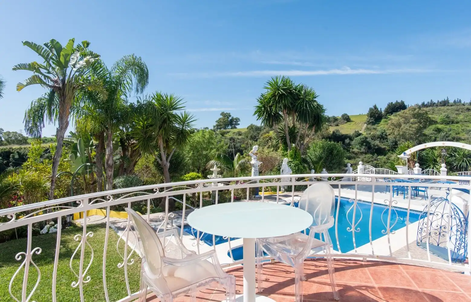 Beautiful outdoor terrace with pool, garden, and seating area in Los Llanos, Estepona.