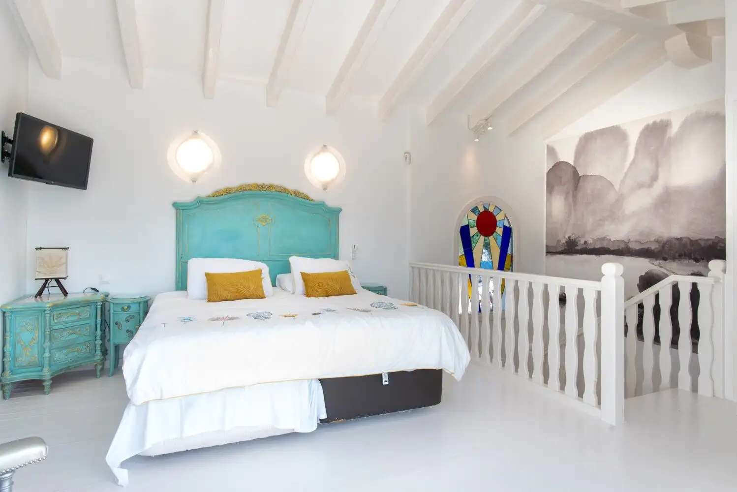 Elegant bedroom in Los Llanos, Estepona featuring a turquoise headboard and modern decor.