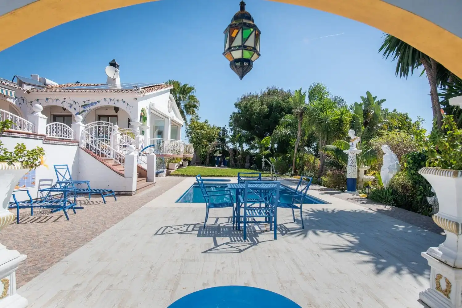 Luxury villa outdoor terrace in Estepona with garden and seating area.