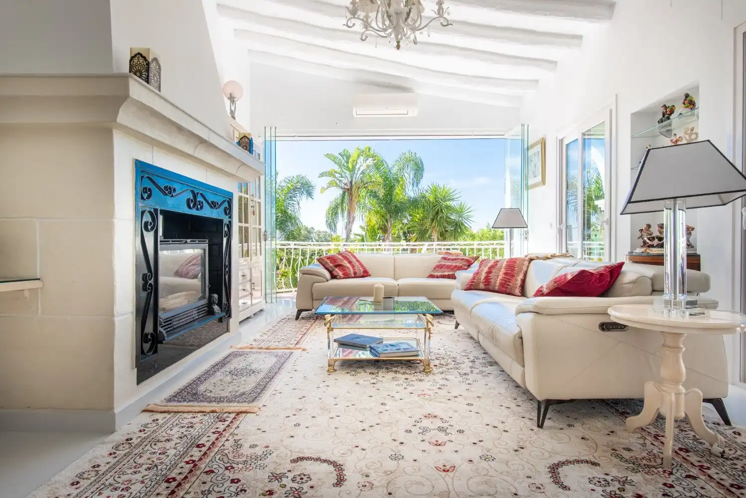 Bright living room with elegant furniture and large windows overlooking lush greenery in Estepona.