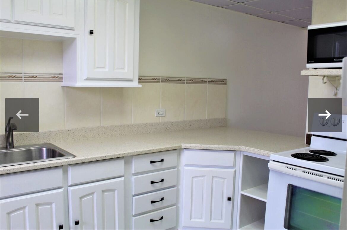 Modern kitchen with white cabinetry and beige countertops, ideal for comfortable living.