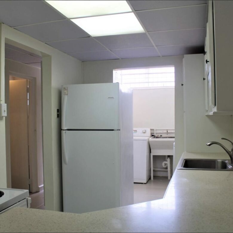 Kitchen with refrigerator, stove, and sink in a Fairways Maraval property.