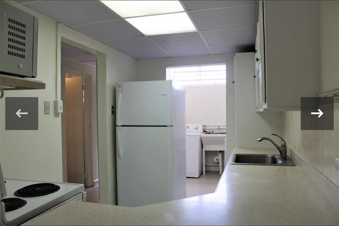 Kitchen with refrigerator, stove, and sink in a Fairways Maraval property.