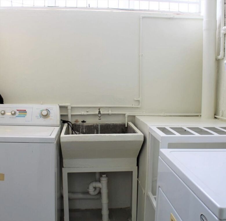 Efficient laundry area with washer, dryer, and utility sink in Trinidad townhouse.