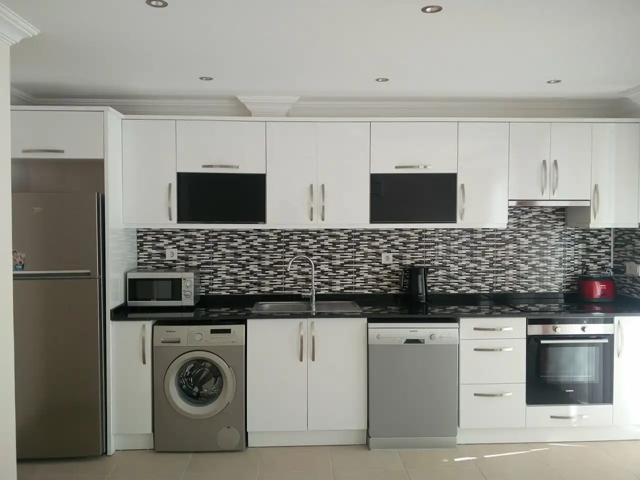 Apartment kitchen with modern appliances and sleek design in Orka Residence, Ovacık.