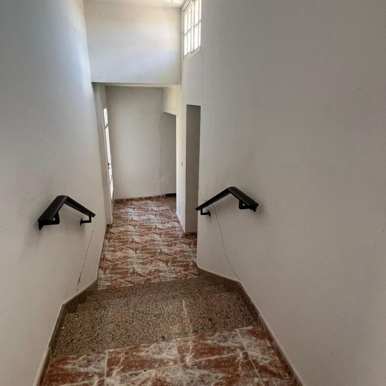 Interior staircase with black handrails in a bright, airy house in Taboada, Galicia.
