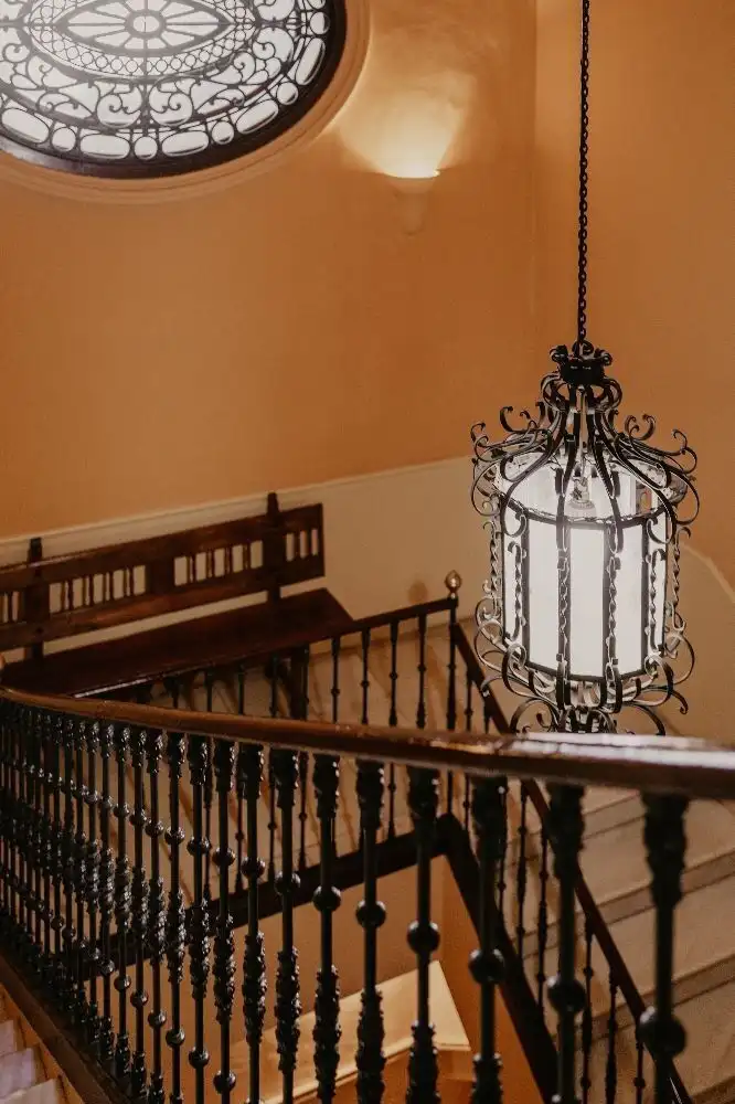 Charming interior view of a Malaga penthouse featuring a decorative staircase and classic lighting f.