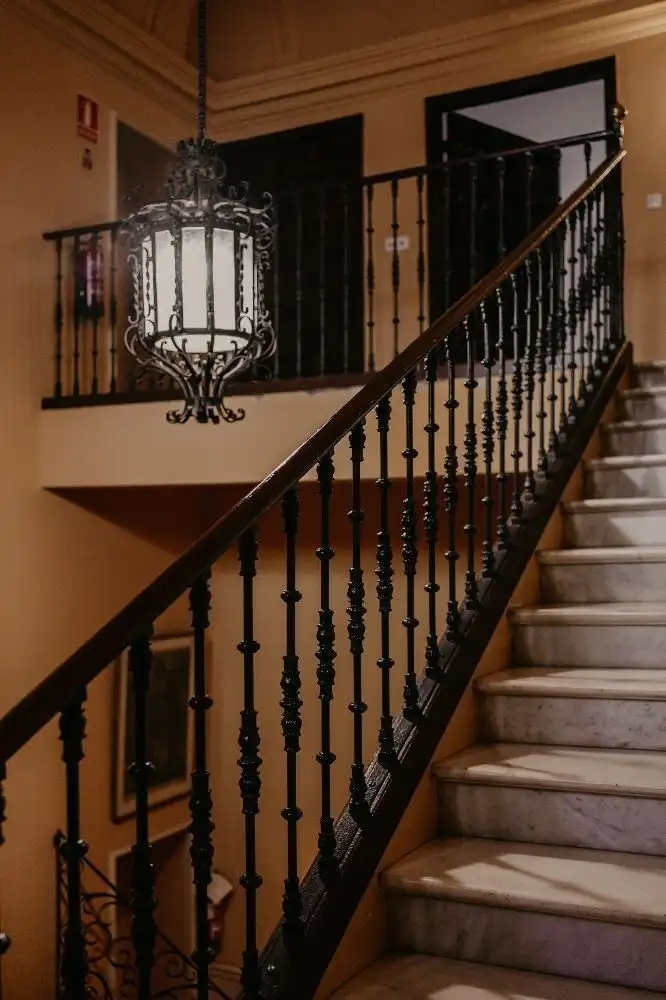Stunning interior view of Malaga penthouse staircase with decorative black iron railing.