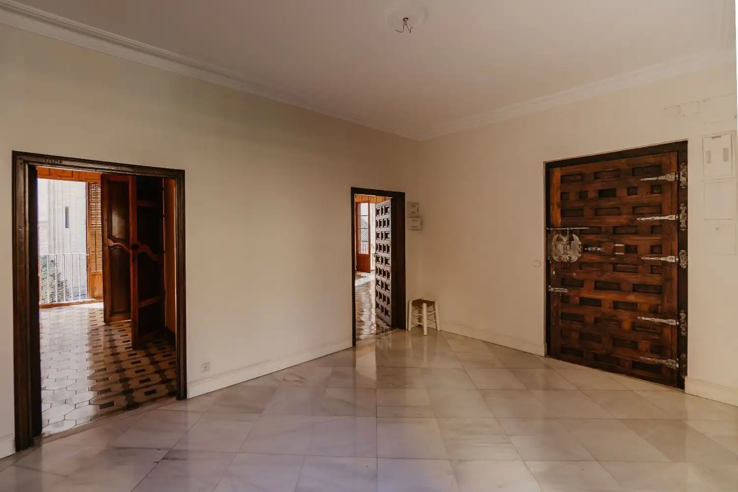 Spacious Malaga penthouse living room featuring rustic wooden doors and ample natural light.