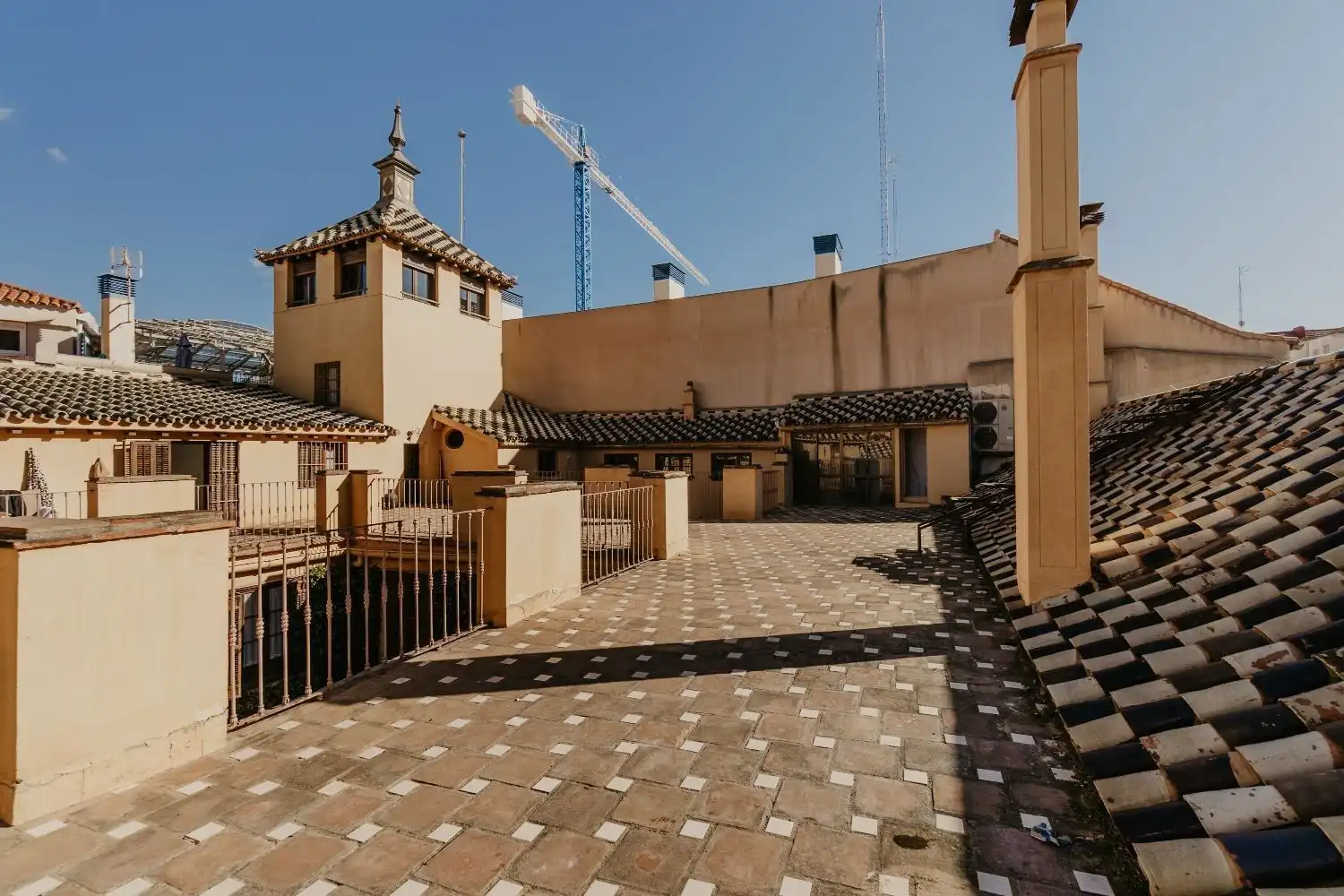 Penthouse terrace in Malaga's historic center with panoramic city views and traditional Spanish arch.
