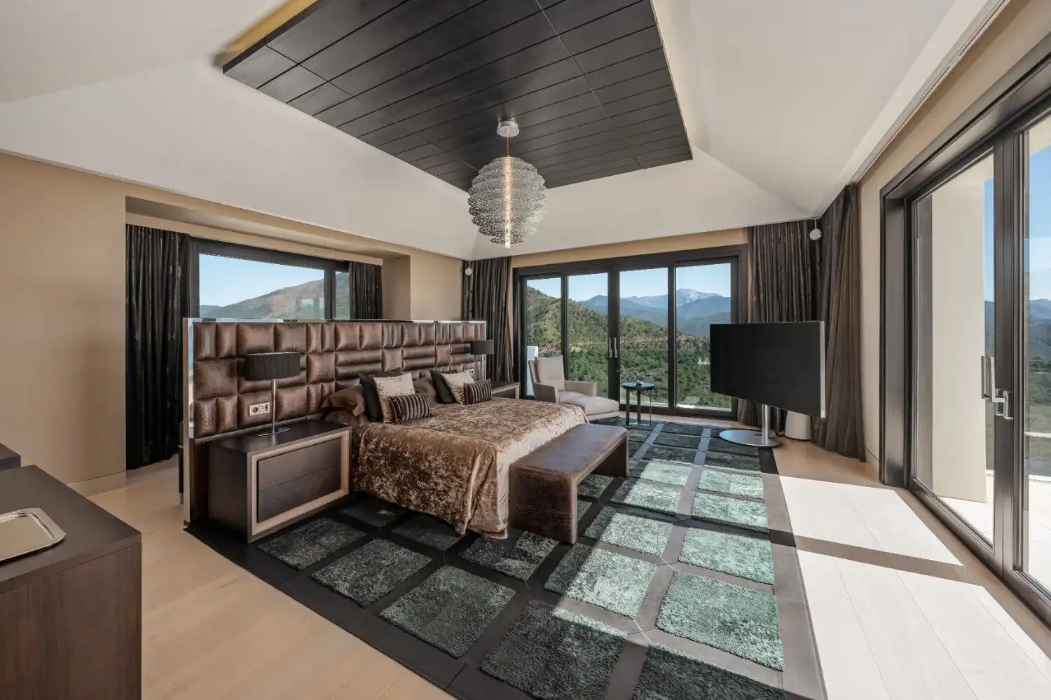 Luxury bedroom with large windows showcasing scenic mountain views in La Zagaleta Benahavis.