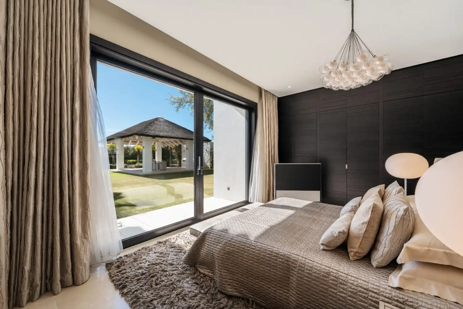 Luxury bedroom with large windows overlooking scenic outdoor area in La Zagaleta Benahavis.