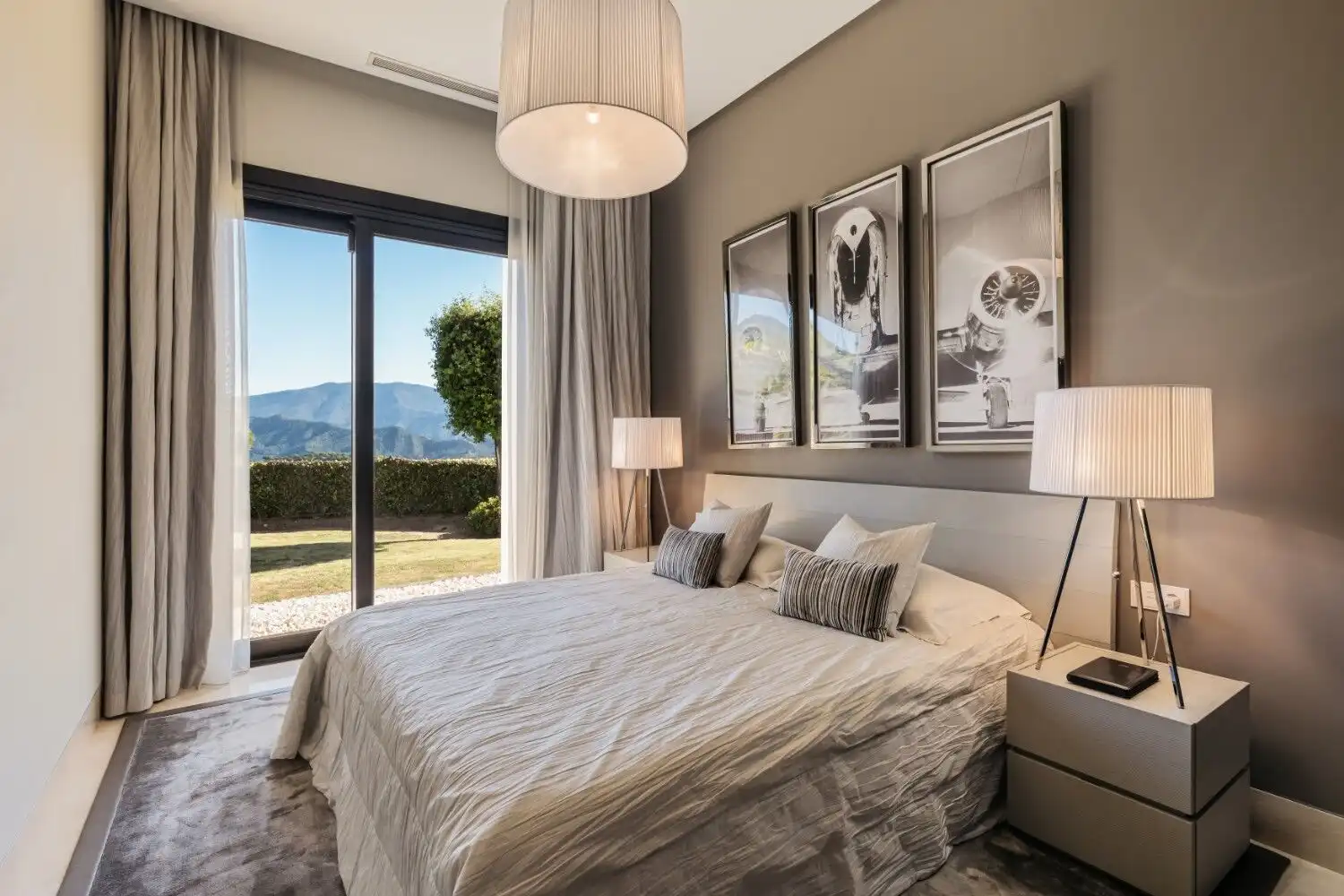 Luxury bedroom with large windows showcasing scenic mountain views in La Zagaleta.