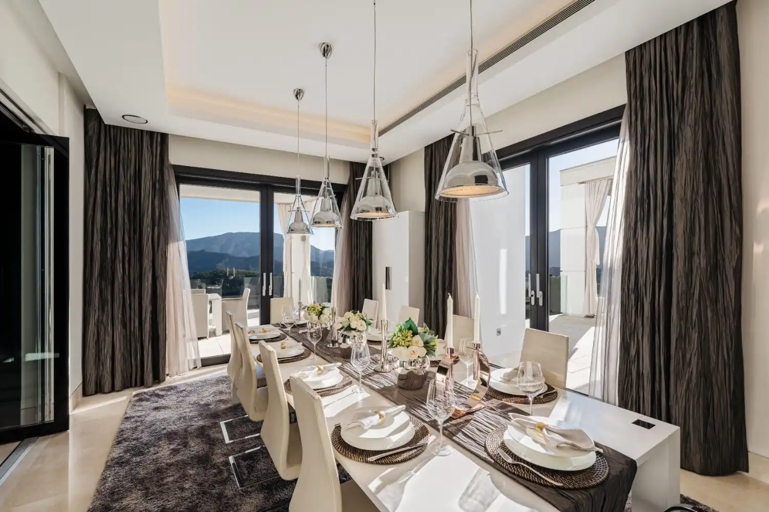 Luxury mansion dining room with large windows showcasing scenic mountain views in La Zagaleta Benaha.