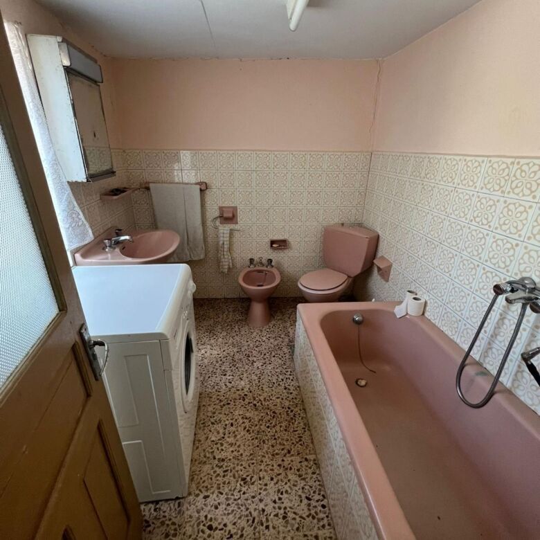 Bathroom with pink fixtures in a traditional Galicia home.