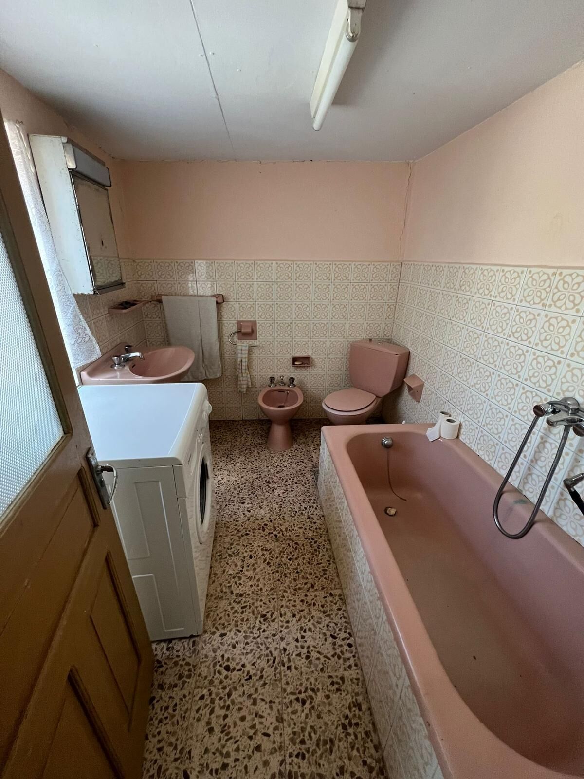 Bathroom with pink fixtures in a traditional Galicia home.