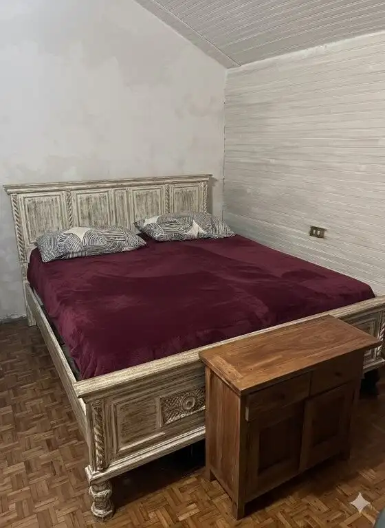 Beautiful bedroom with vintage wooden bed and cozy decor in Piedmont.