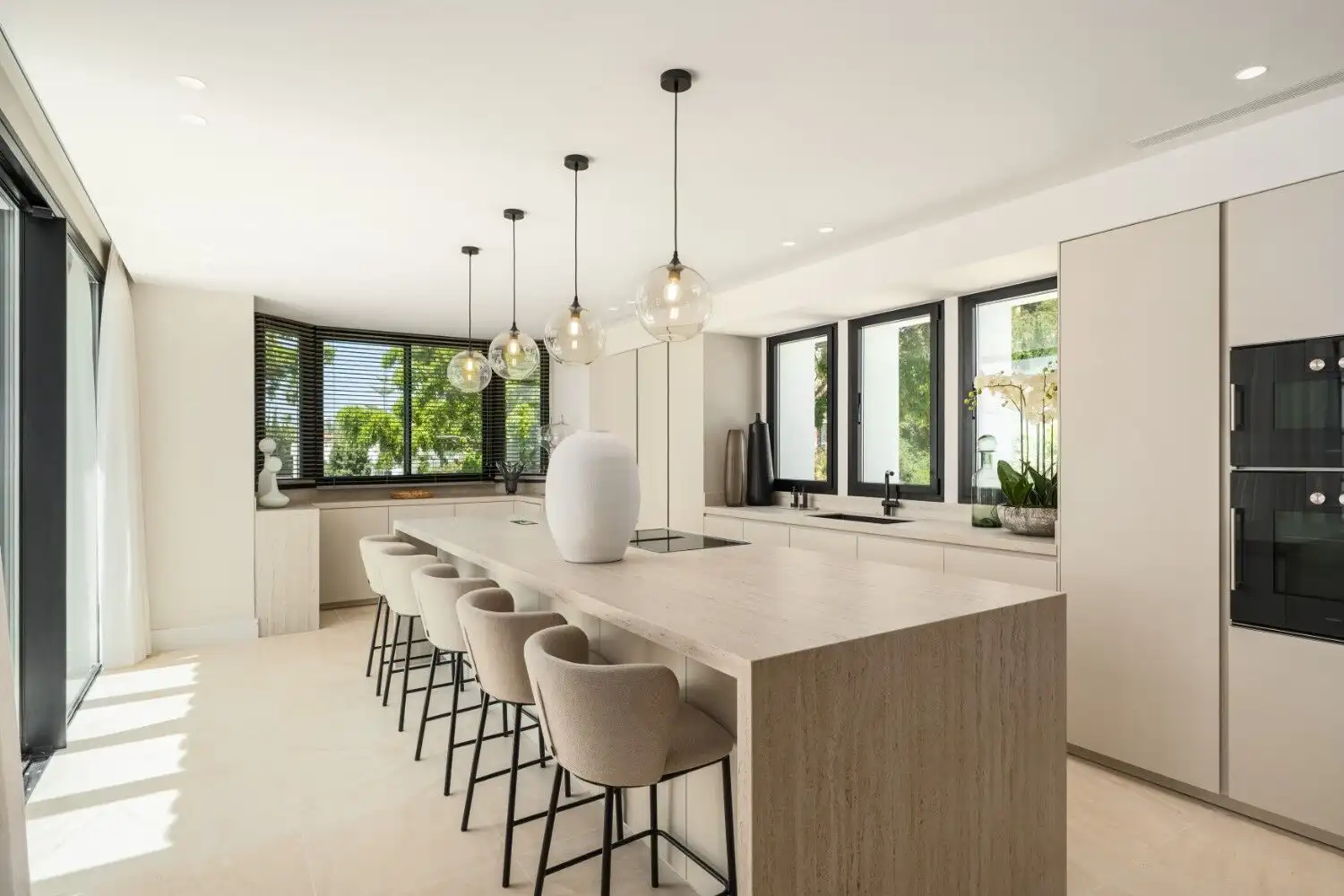 Luxury villa kitchen with modern design and large windows showcasing stunning panoramic views.