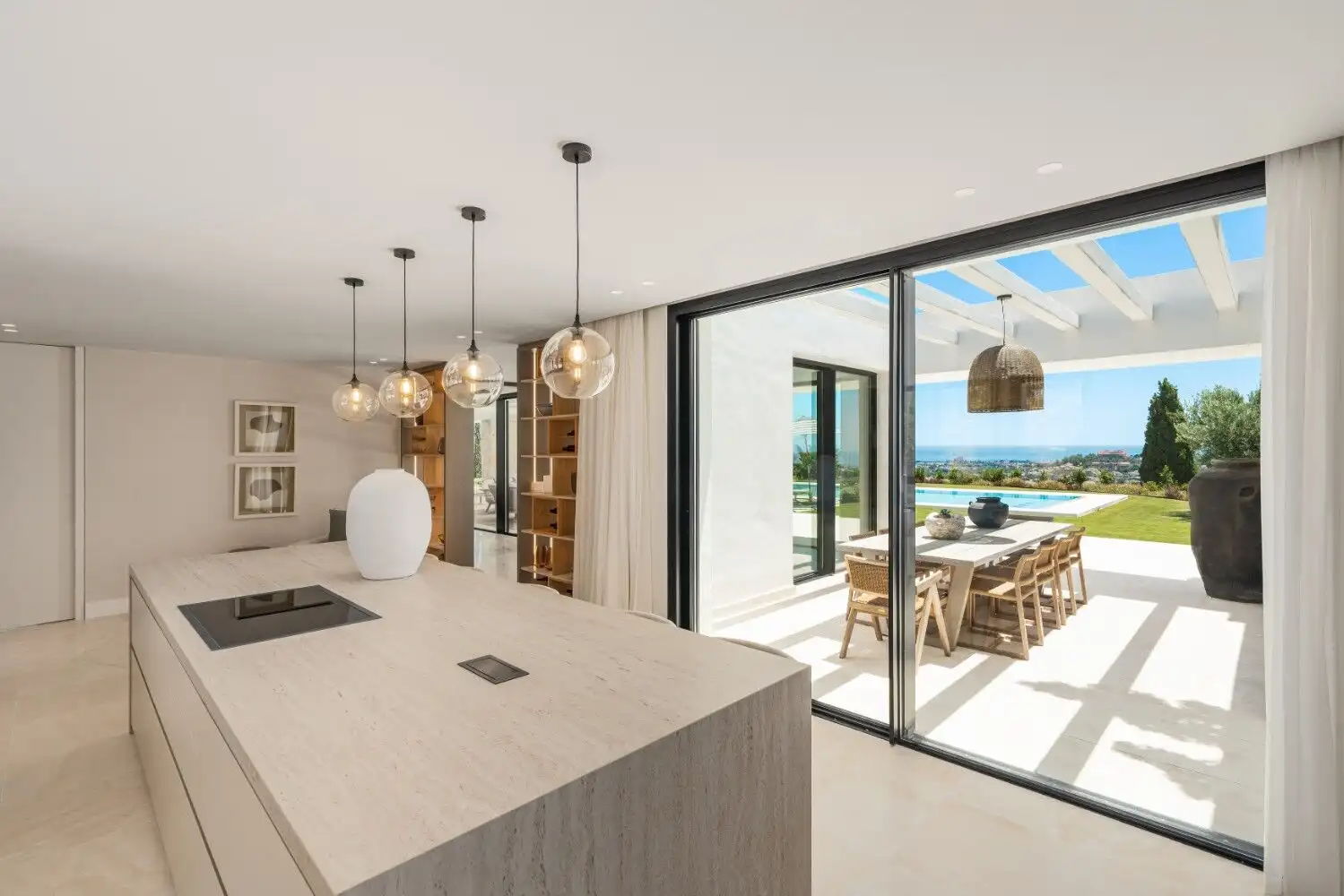 Luxury villa interior with modern design and large glass doors overlooking the ocean.