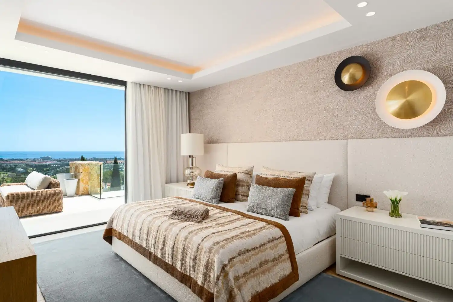 Elegant bedroom featuring a large window overlooking the sea and a spacious balcony. Perfect for rel.