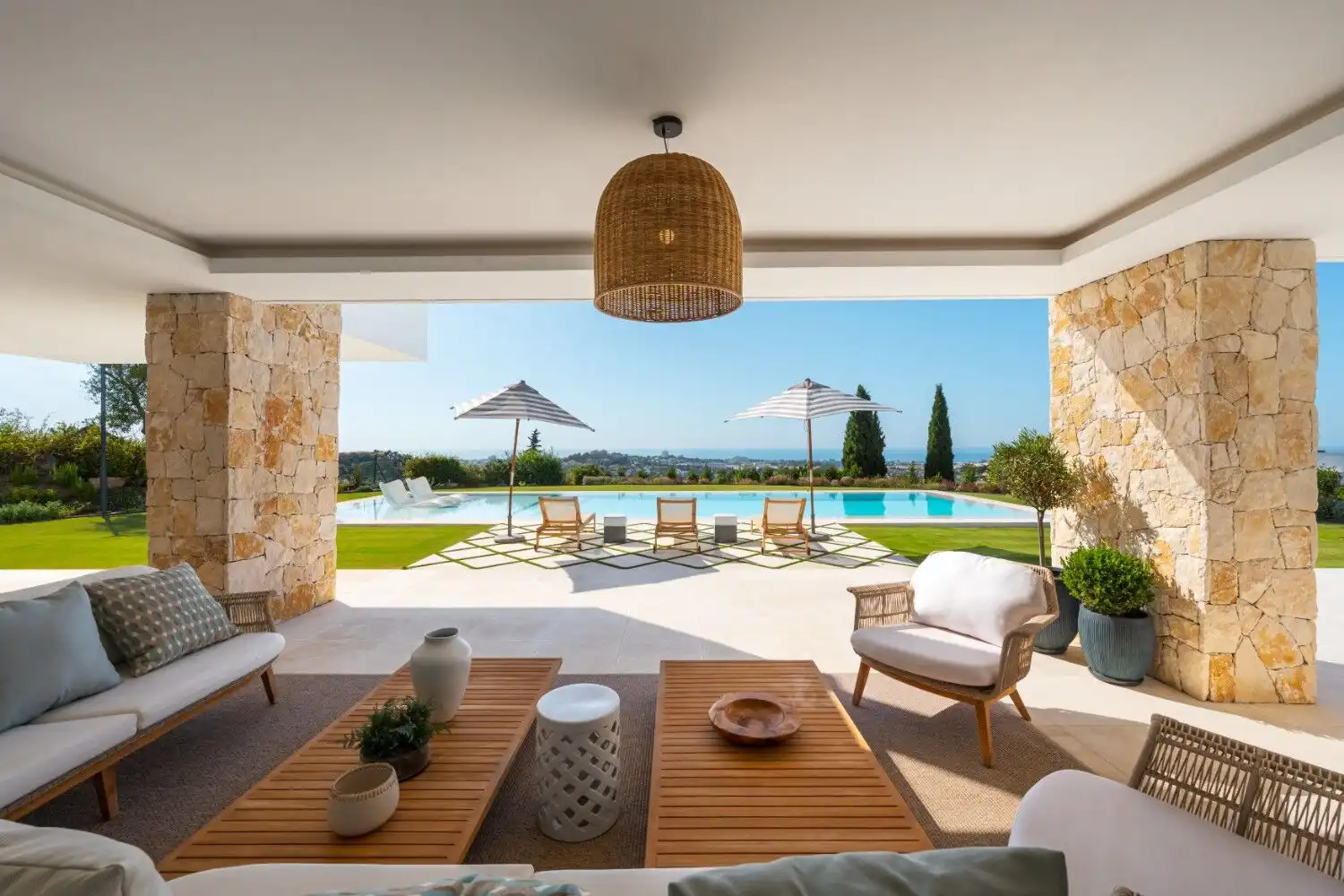 Luxury villa with pool overlooking scenic landscape and outdoor lounging area.