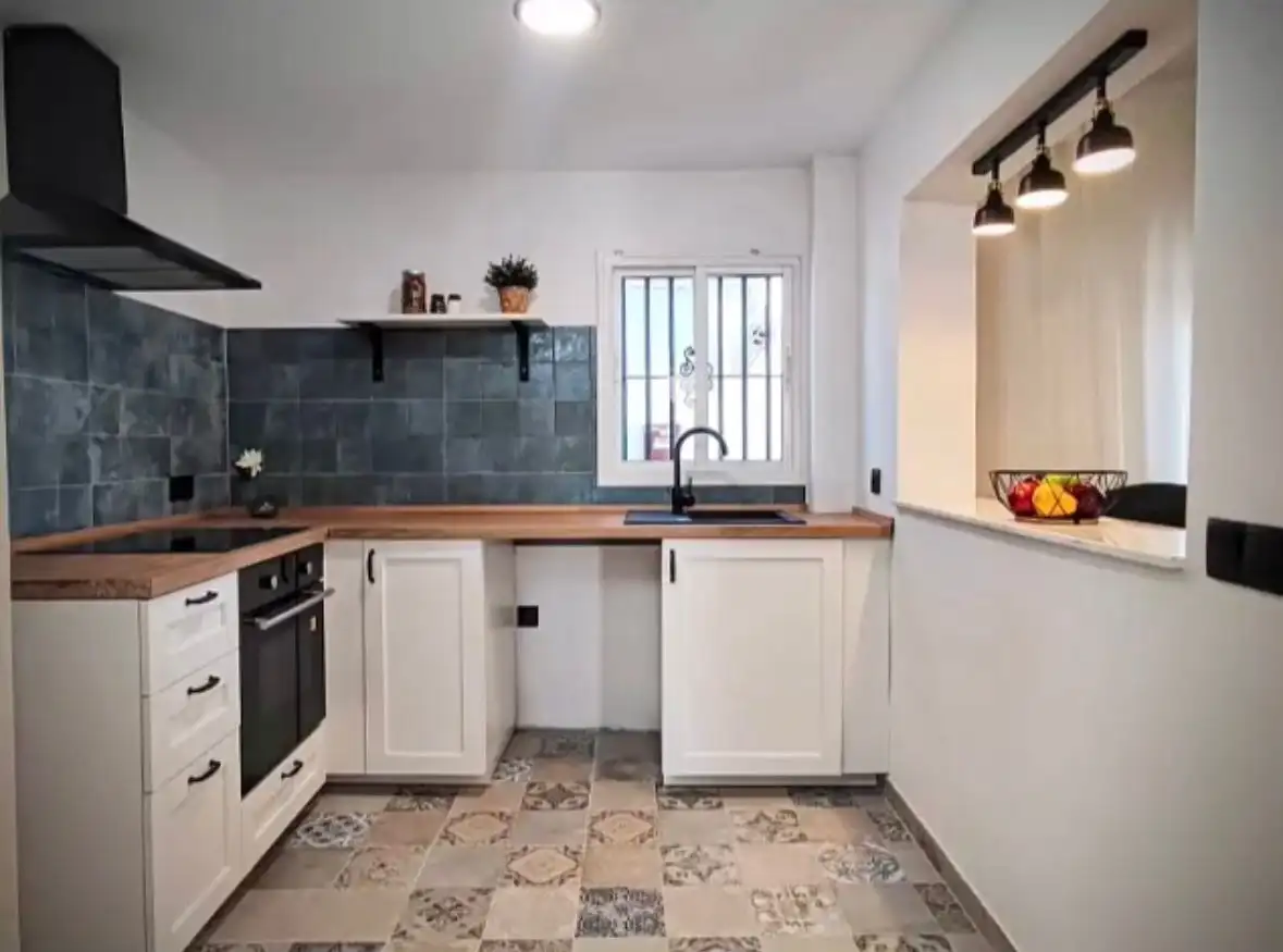 Cozy kitchen in Torresoto with modern appliances and rustic decor. Bright space featuring white cabi.