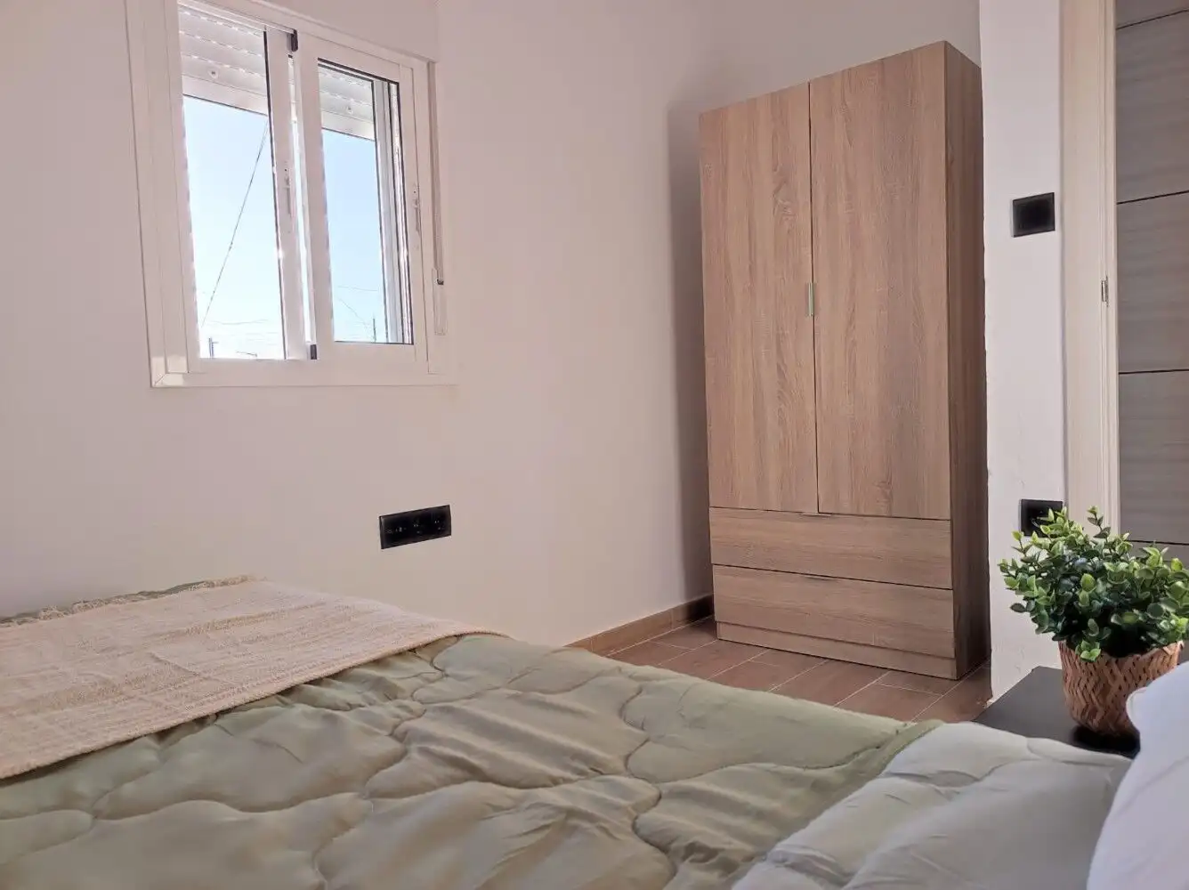 Cozy bedroom in a charming Torresoto casita with natural light and modern furnishings.