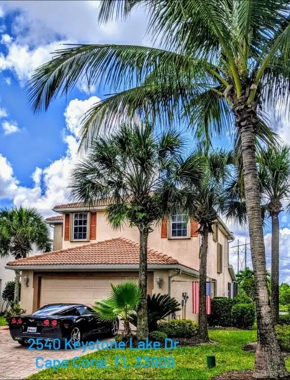 Waterfront villa with lush palm trees in Cape Coral, Florida.