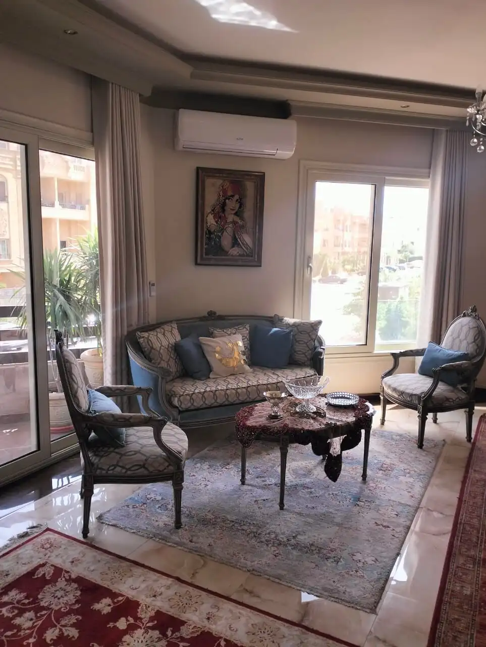 Elegant living room with classic furniture and large windows in New Cairo apartment.
