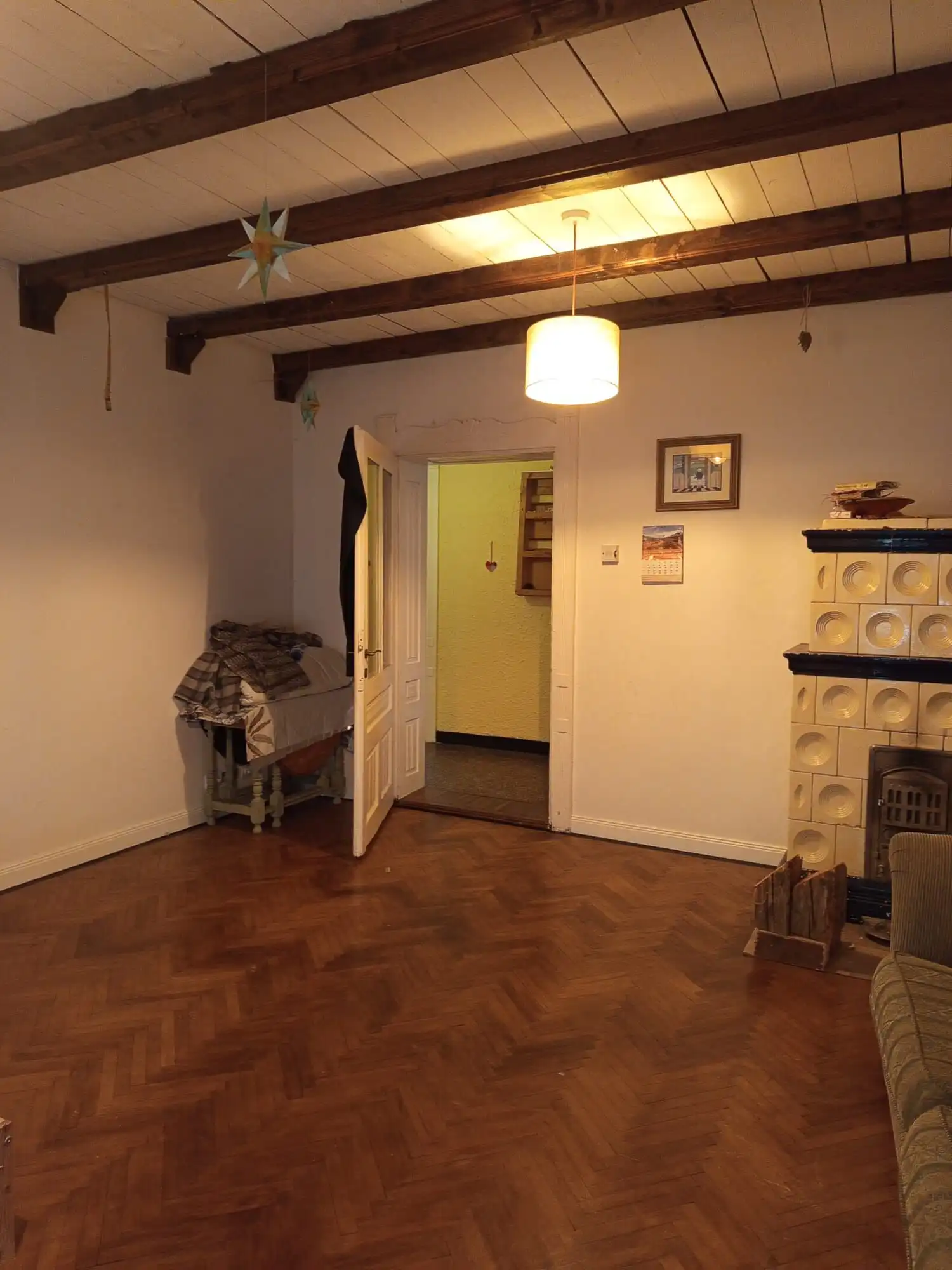 Cozy living room with wooden beams and warm lighting in Vulcan Brasov home for sale.