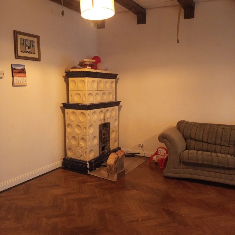 Interior of a cozy living room featuring a vintage fireplace and a comfortable sofa.