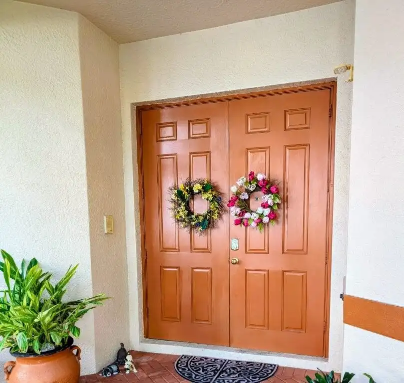 Waterfront villa entrance with floral wreaths in Cape Coral, Florida.