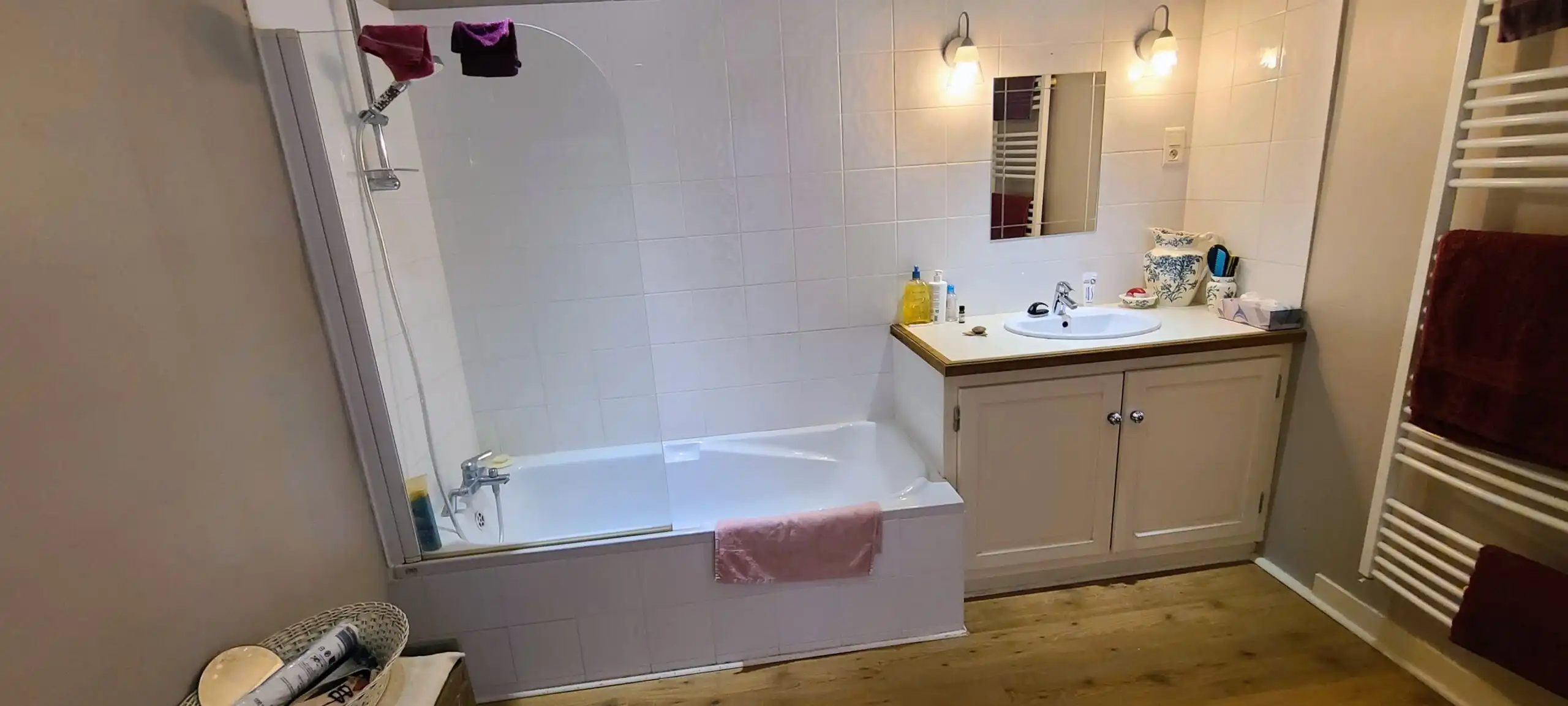 Bright bathroom featuring a bathtub, sink, and mirror in a charming Monségur townhouse.