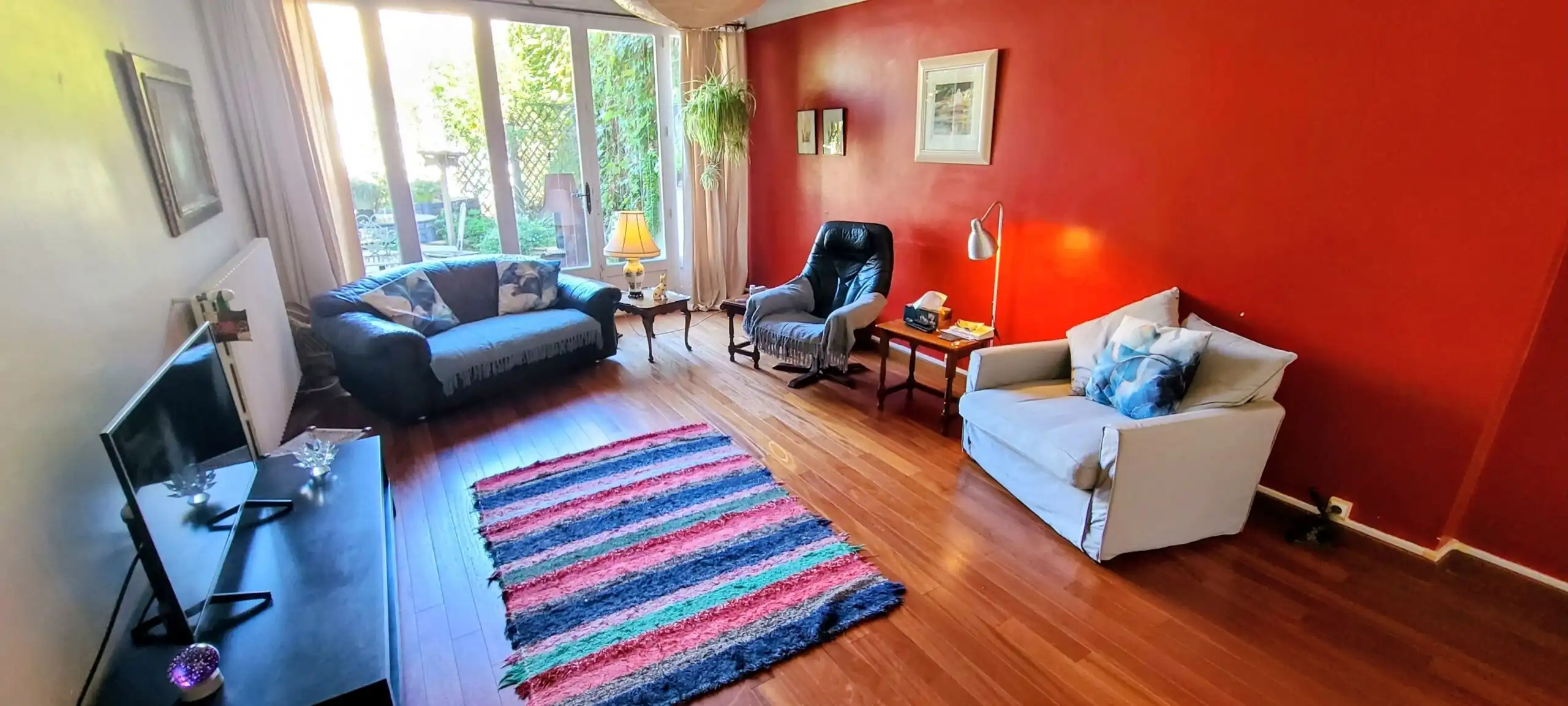 Bright living room with comfortable seating, wooden floors, and natural light.