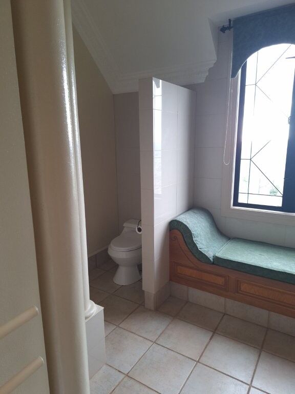 Elegant bathroom with a toilet and a cozy window seat in a luxury château.