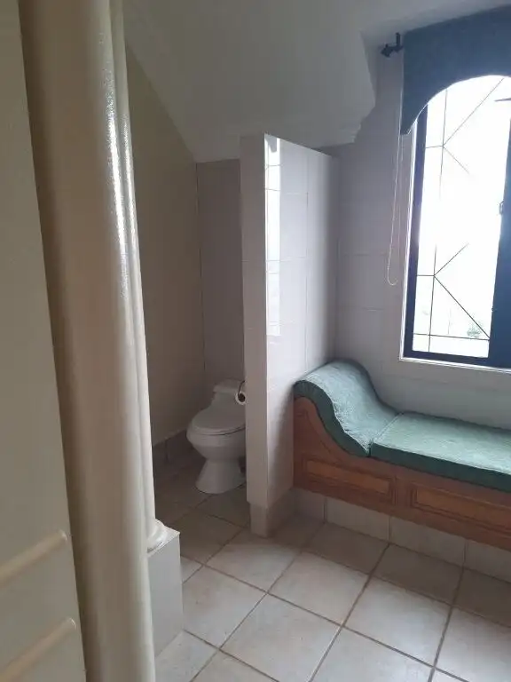 Elegant bathroom with a toilet and a cozy window seat in a luxury château.