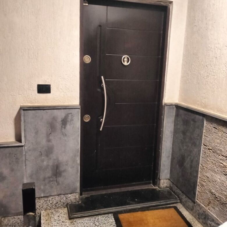 Black apartment door with modern handle in New Cairo residence.