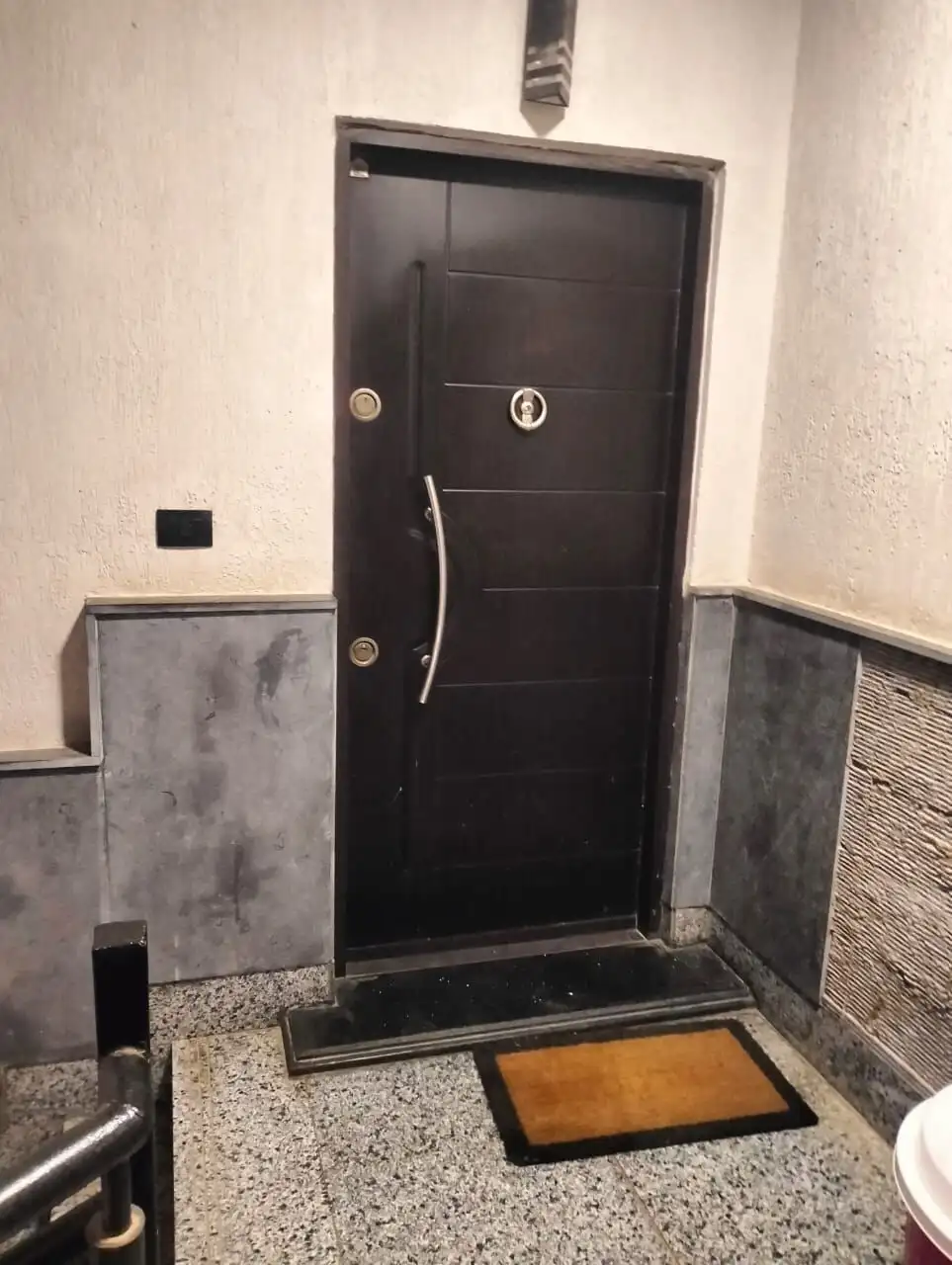 Black apartment door with modern handle in New Cairo residence.