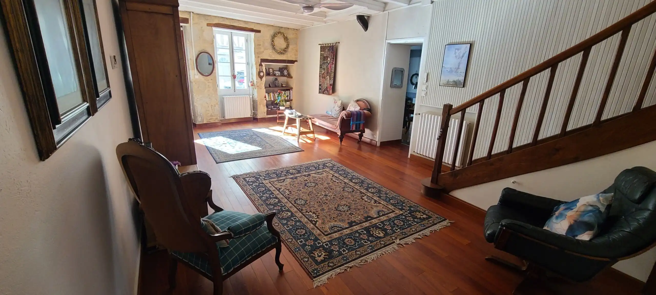 Bright living room with traditional decor and hardwood floors in Monségur. Perfect for comfortable f.