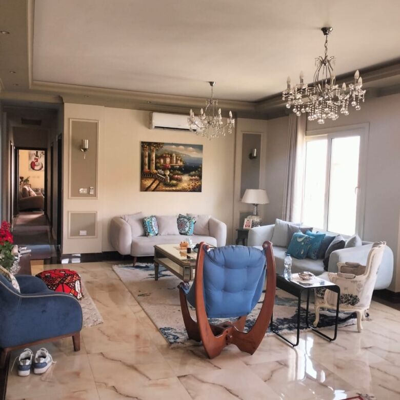 Spacious living room of a luxury 3-bedroom apartment in New Cairo, featuring elegant furniture and m.