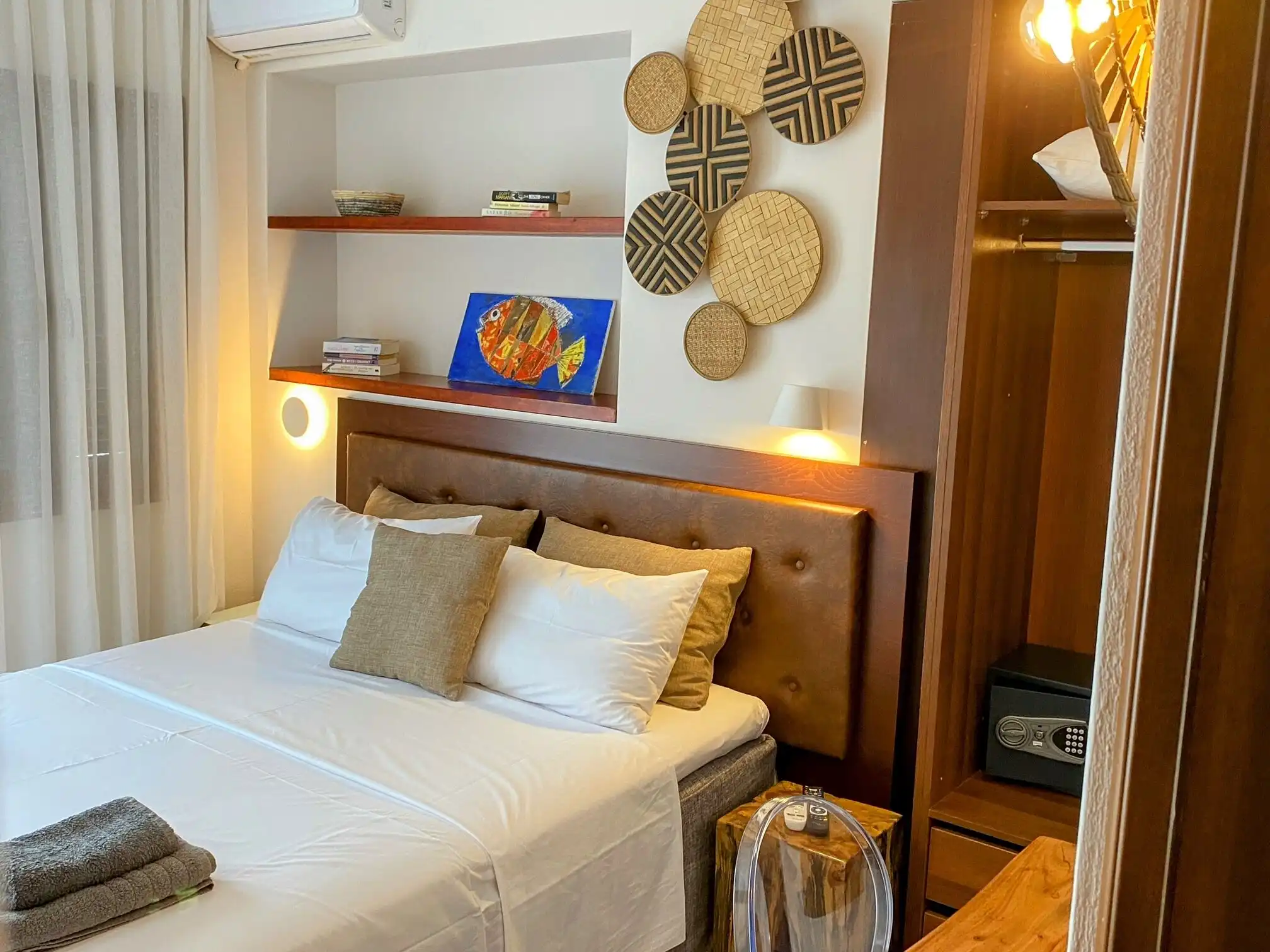 Elegant bedroom featuring a comfortable bed, decorative pillows, and contemporary wall decorations.