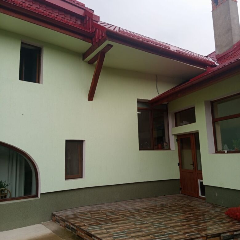 Spacious 9-bedroom house for sale in Vulcan Brasov, featuring a stylish exterior and a large wooden.