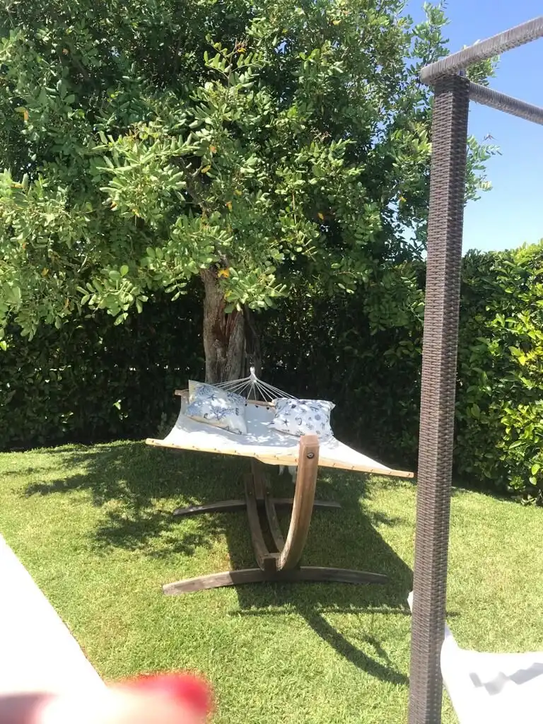 Panoramic villa garden with hammock and lush greenery in Otranto, Puglia.