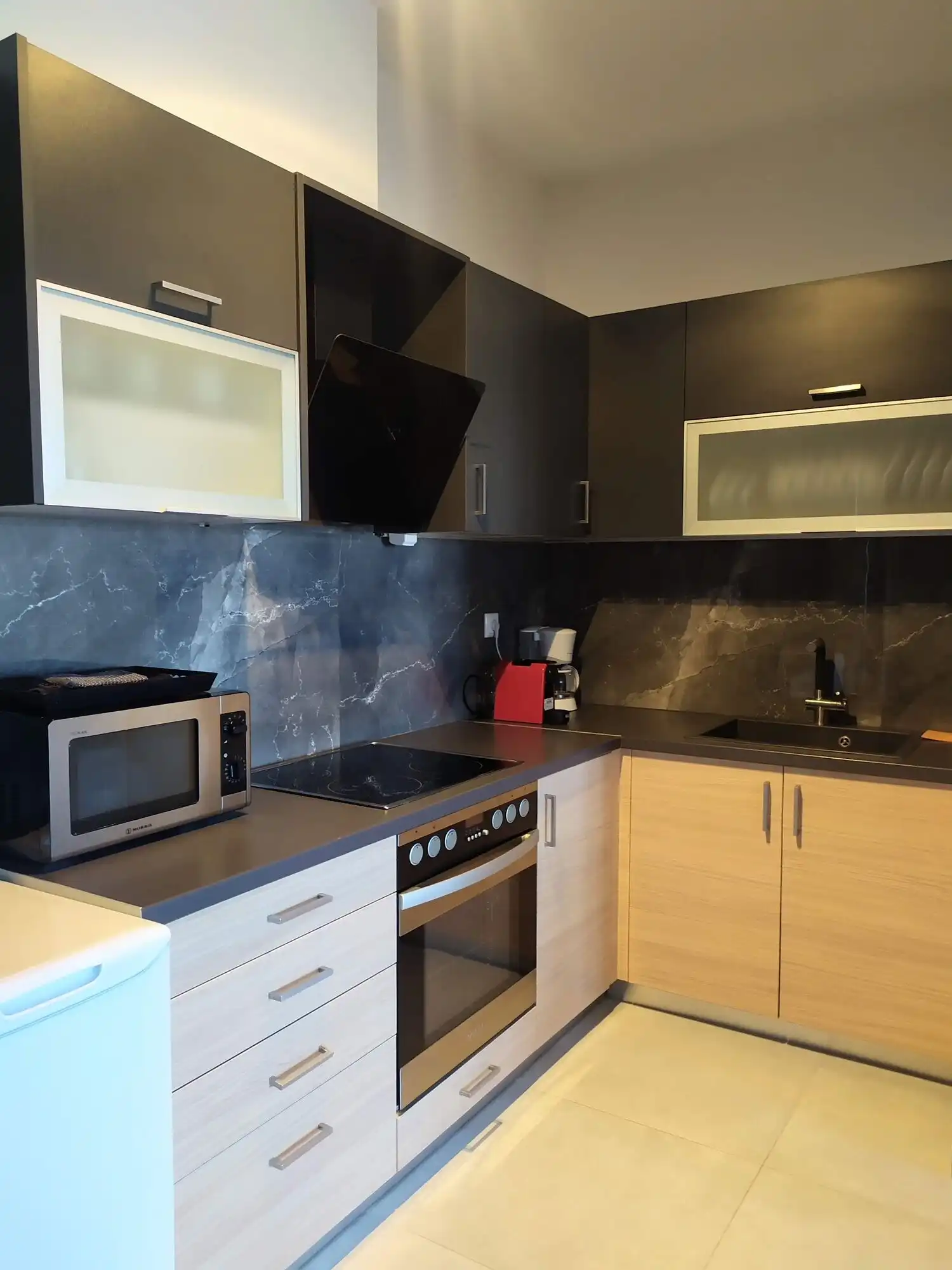 View villa kitchen with black and wood cabinets in Skiathos, Greece.