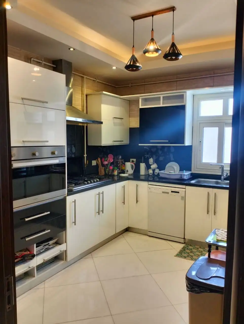 Modern kitchen with sleek white cabinets and black countertops in New Cairo.