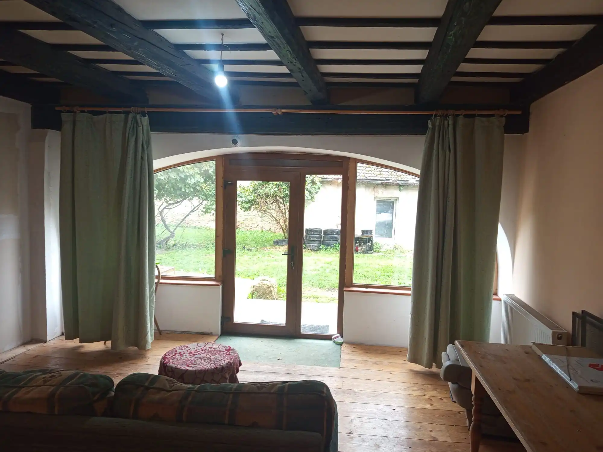 Charming living room featuring large windows overlooking a lush garden, perfect for relaxing and enj.