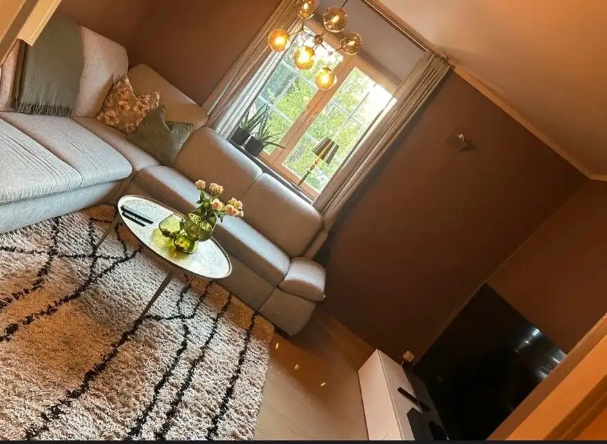 Cozy living room with large window, modern decor, and stylish lighting in Rjukan.