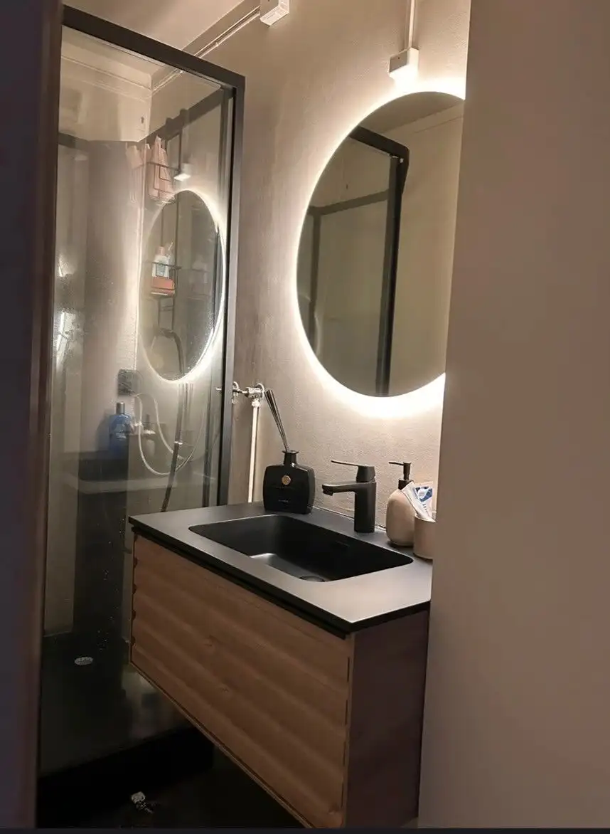 Bright modern bathroom with stylish mirror and sleek sink.