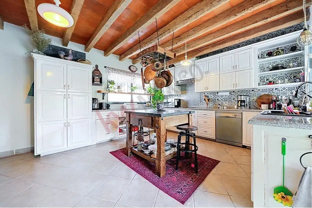 Bright kitchen with rustic wooden ceiling and white cabinetry in San Miguel de Allende.